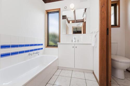 a bathroom with a tub and a sink and a toilet at Swimmers Rest in Port Fairy