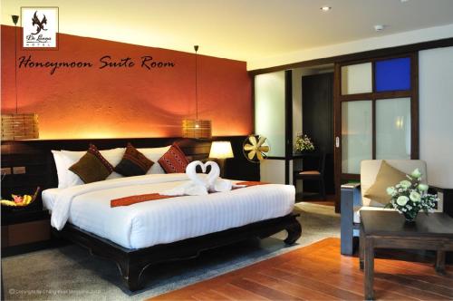 a bedroom with a large bed with a bow on it at De Lanna Hotel in Chiang Mai