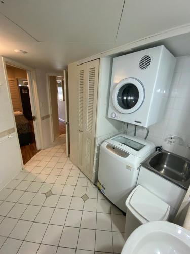 a bathroom with a sink and a washing machine at Il Palazzo Holiday Apartments in Cairns