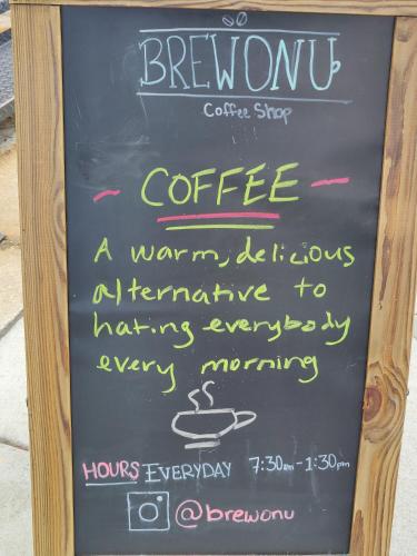 a chalkboard sign for a coffee shop with a cup of coffee at U Street Capsule Hostel in Washington