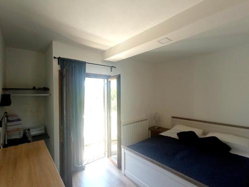 Un dormitorio con una cama y una puerta corrediza de vidrio. en Apartments with parking space Sumartin, Brac - 11926, en Sumartin