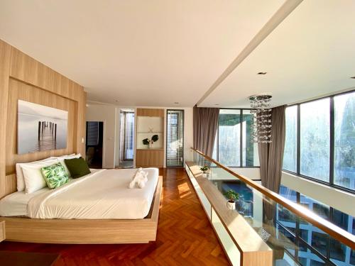 Icon park phuket condo في فوكيت تاون: غرفة نوم بسرير كبير ونوافذ كبيرة