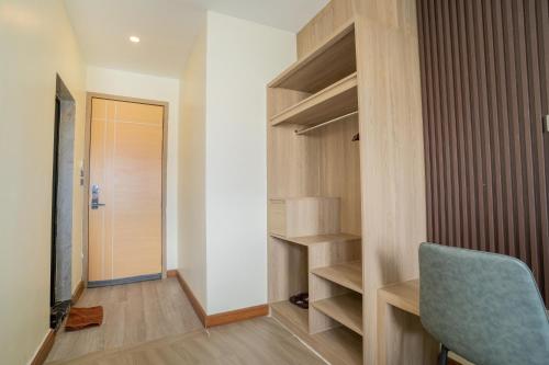a room with a closet with a blue chair and a door at Hak Heng Hotel in Krong Poi Pet