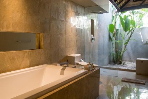 a bathroom with a tub and a sink at The Amala Boutique Retreat in Seminyak