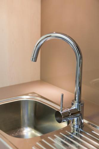 a kitchen sink with a chrome kitchen faucet at Kings Of Riccarton Motel- Close to Railway Station and Airport with Shuttle service in Christchurch
