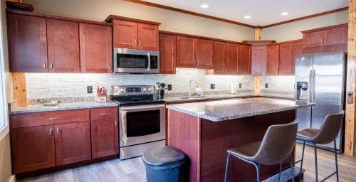 a kitchen with wooden cabinets and stainless steel appliances at House close to Acadia National Park in Ellsworth