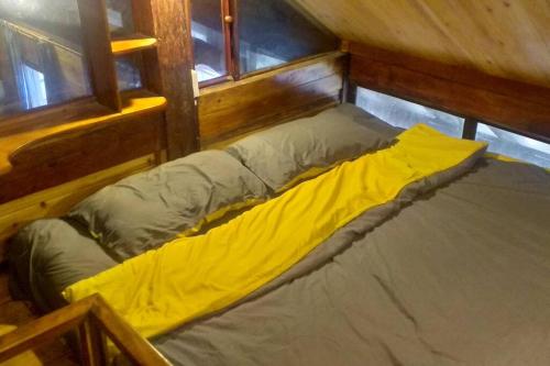 a bed with a yellow blanket in a room at Fieu House in Lao Cai