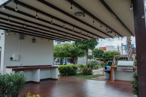 a patio with a wooden bench under awning at Casa LU~NA hermoso alojamiento en privada in Culiacán