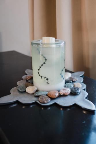 a candle in a glass jar on a pile of rocks at Casa LU~NA hermoso alojamiento en privada in Culiacán