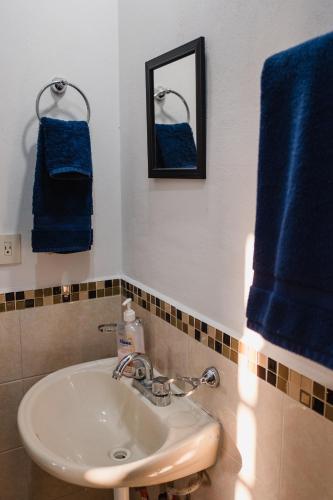 a bathroom with a sink and two blue towels at Casa LU~NA hermoso alojamiento en privada in Culiacán