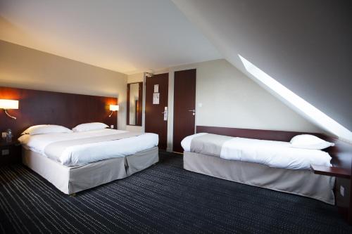 a hotel room with two beds and a staircase at Kyriad Saint-Malo Dinard in La Richardais