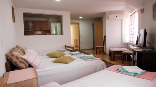 um quarto com duas camas e uma secretária em Guesthouse "INES" em Doboj