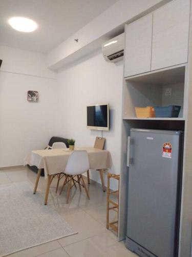 a kitchen and dining room with a table and a refrigerator at Nice Cozy Apartment I-Soho I-City (1-4 pax) studio in Shah Alam