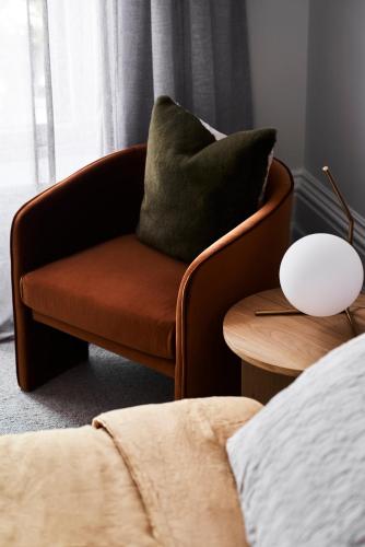 a brown chair with a pillow on a table at Hotel Ernest Bendigo in Bendigo