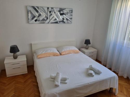 a bedroom with a bed with two towels on it at Apartments Smilja - great location in Supetar