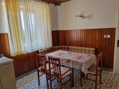 a dining room with a table and chairs and a window at Apartments Smilja - great location in Supetar