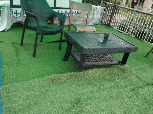 a table and chairs on a lawn with green grass at S Group Of Houseboat in Srinagar