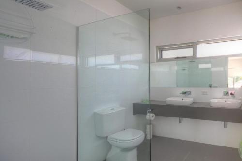 a white bathroom with a toilet and a sink at Villa Moyne in Port Fairy