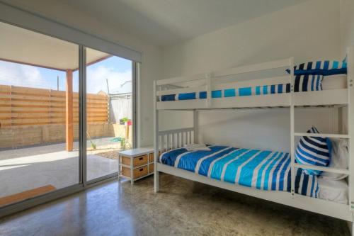 a bedroom with bunk beds and a sliding glass door at Villa Moyne in Port Fairy