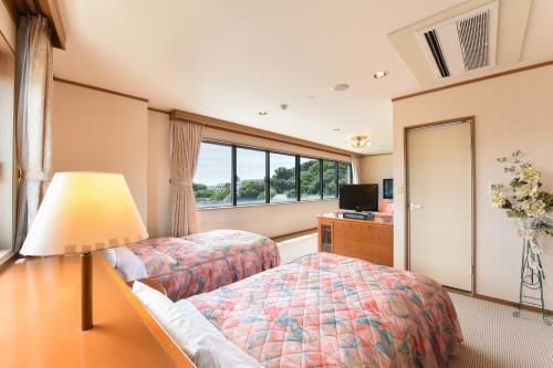 a bedroom with two beds and a window at Iki Marina Hotel in Iki
