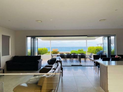 a living room with a couch and a table with chairs at Beachfront apartment The Entrance Central Coast in The Entrance
