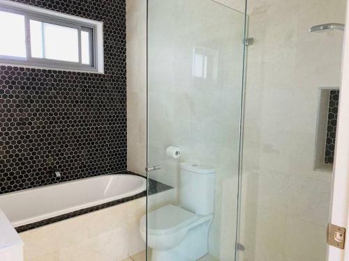 a bathroom with a tub and a toilet and a shower at Beachfront apartment The Entrance Central Coast in The Entrance