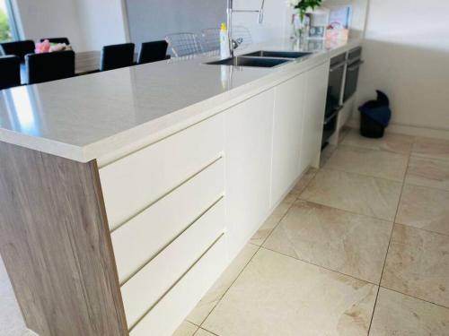 a kitchen with a white counter and a sink at Beachfront apartment The Entrance Central Coast in The Entrance