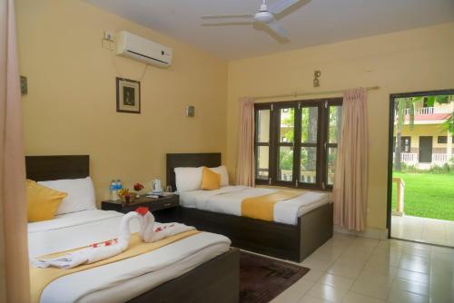 una camera da letto con due letti e una finestra di Hotel Rainforest a Sauraha