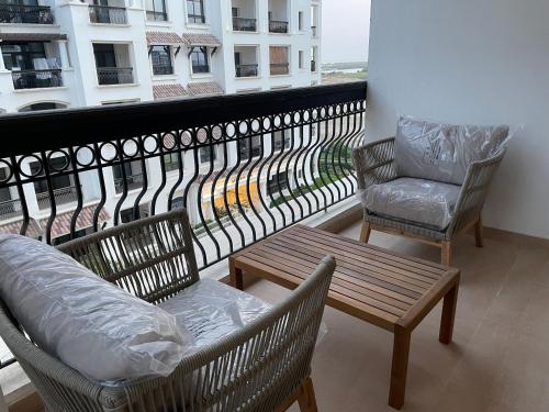 a balcony with two chairs and a table and a couch at Ansam, Yas Island in Abu Dhabi