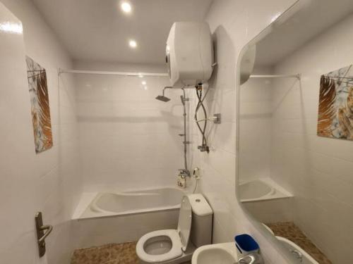 a white bathroom with a toilet and a bath tub at (AB By The River) 2BR 901 With Great View in Cairo