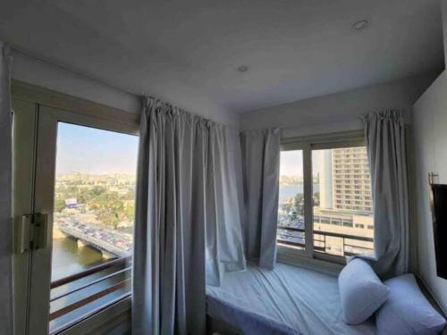 a bedroom with a bed and a large window at (AB By The River) 2BR 901 With Great View in Cairo