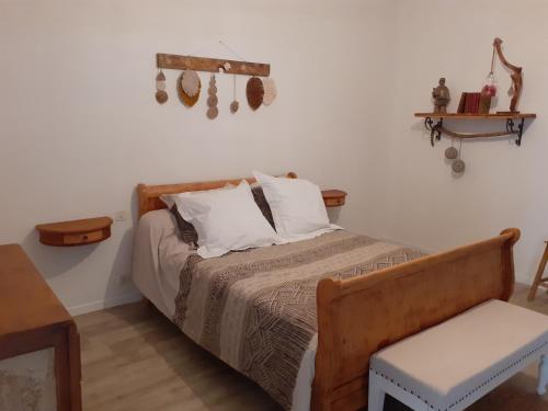 a bedroom with a bed and a table and a chair at La rivière in Damazan