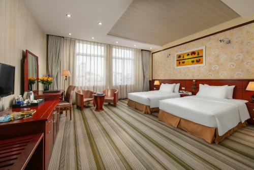 una camera d'albergo con due letti e una televisione di Hoa Dao Hotel a Hanoi