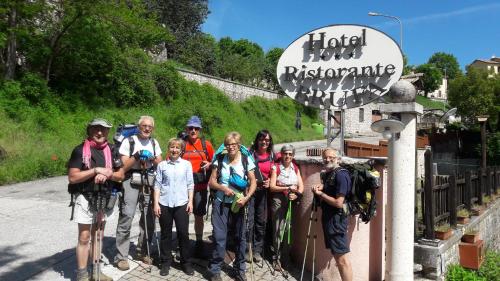 a group of people posing for a picture in front of a sign at Hotel Brufa in Monteleone di Spoleto
