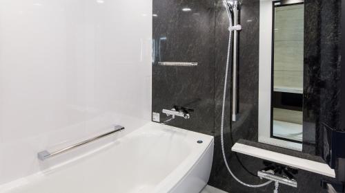 埼玉的住宿－Hotel Metropolitan Saitama-Shintoshin，带淋浴、盥洗盆和浴缸的浴室