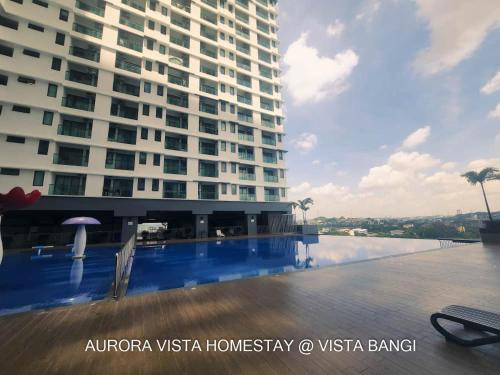 a large building with a swimming pool in front of a building at Aurora Vista Homestay Bangi at Vista Bangi With WIFI NETFLIX GYM SAUNA COWAY SWIMMING POOL-RIVER VIEW in Kajang