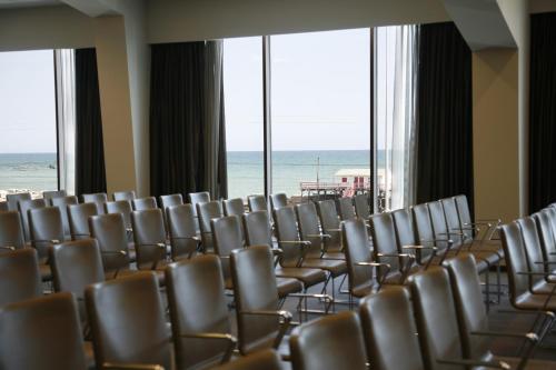 a room with chairs and the ocean in the background at Ego Hotel in Ancona