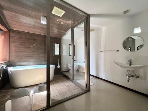 uma casa de banho com uma banheira, um WC e um lavatório. em UMIBE IseShima em Shima