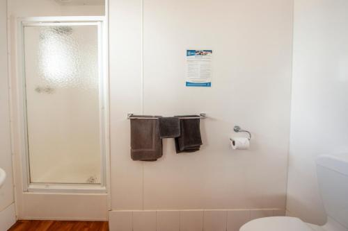 a bathroom with a shower and a toilet and towels at Wallaroo Beachfront Tourist Park in Wallaroo