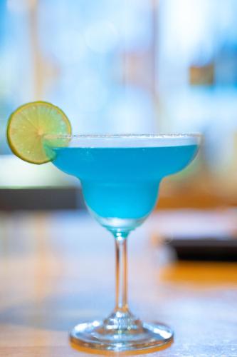 a blue margarita in a glass with a lime at Hak Heng Hotel in Krong Poi Pet