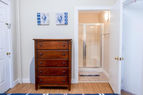 a bathroom with a wooden dresser and a shower at Downtown Apartments in Bar Harbor in Bar Harbor