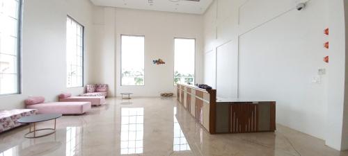 a living room with pink furniture and large windows at The Utopia Resort Sanchi in Sānchi
