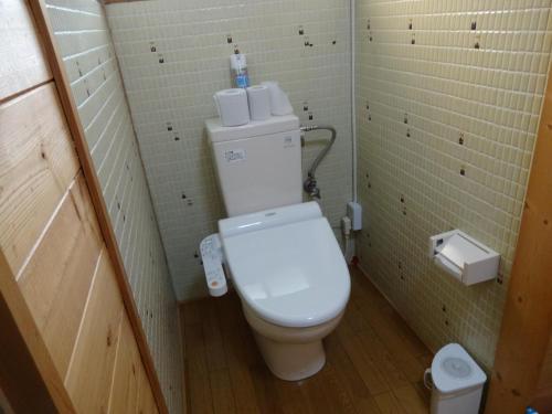 a bathroom with a toilet in a small room at Oomukou Ryokan in Hakuba