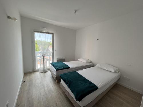 deux lits dans une chambre blanche avec une fenêtre dans l'établissement Superbe T3 de 66 m² centre ville Arcachon avec parking et balcon à 200m de la plage - FR-1-374-196, à Arcachon