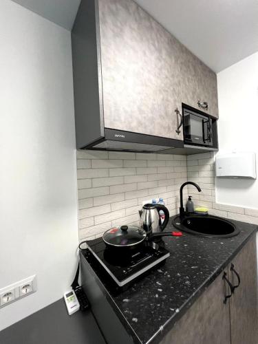 a kitchen with a stove with a pot on it at Апартаменти MYFREEDOM поруч із метро Вокзальна in Kyiv