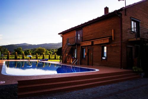 a house with a swimming pool next to a building at GorodOk in Migovo