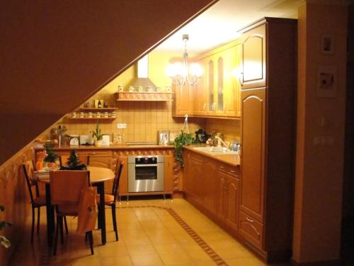 una cocina con armarios de madera y una mesa con comedor. en Ferienwohnung, en Hévíz