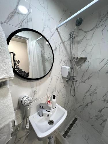 MYFREEDOM Апартаменти Солом'янський район في كييف: حمام أبيض مع حوض ومرآة