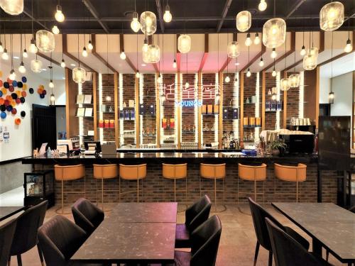 a restaurant with tables and chairs and a bar at Mercure Ambassador Seoul Hongdae in Seoul