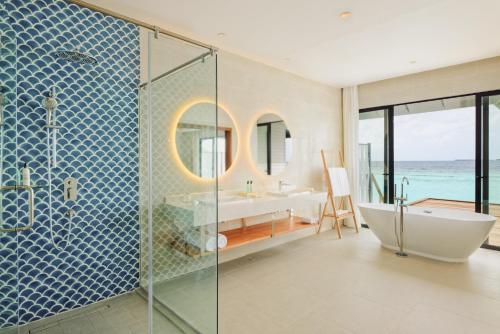 a bathroom with a shower and a tub and a sink at Nova Maldives in Dhangethi